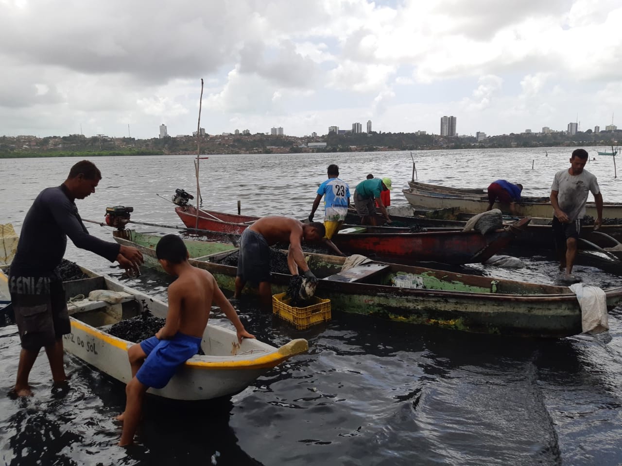 Ao centro, um pescador usa a técnica amadora de colher sururus com engradado de cerveja / Foto: arquivo pessoal Ao centro, um pescador usa a técnica amadora de colher sururus com engradado de cerveja / Foto: arquivo pessoal